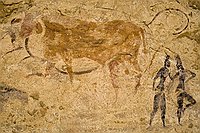 Fresque " le boeuf à l'hydre"  Fresque "le boeuf à l'Hydre". Cette scène repr"sente peut être une cérémonie qui associe un taureau à des jeunes filles qui dansent. Une grosse majorité des scènes rupestres de Jabbaren illustre cette civilisation des pasteurs. : djanet sebeiba jabbaren